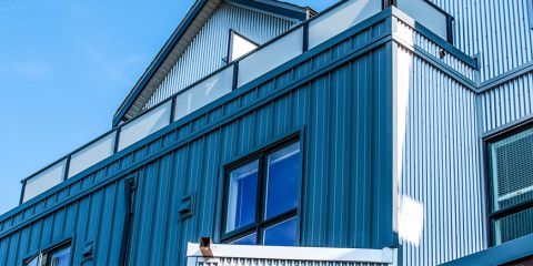 A building exterior clad in dark blue standing-seam metal panelling